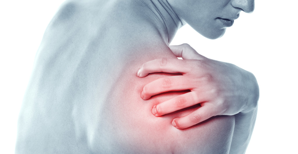 Acute pain in a shoulder at the young women. young girl keeps for a sick shoulder on a white background