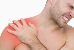 Closeup of young shirtless man with shoulder pain over white background